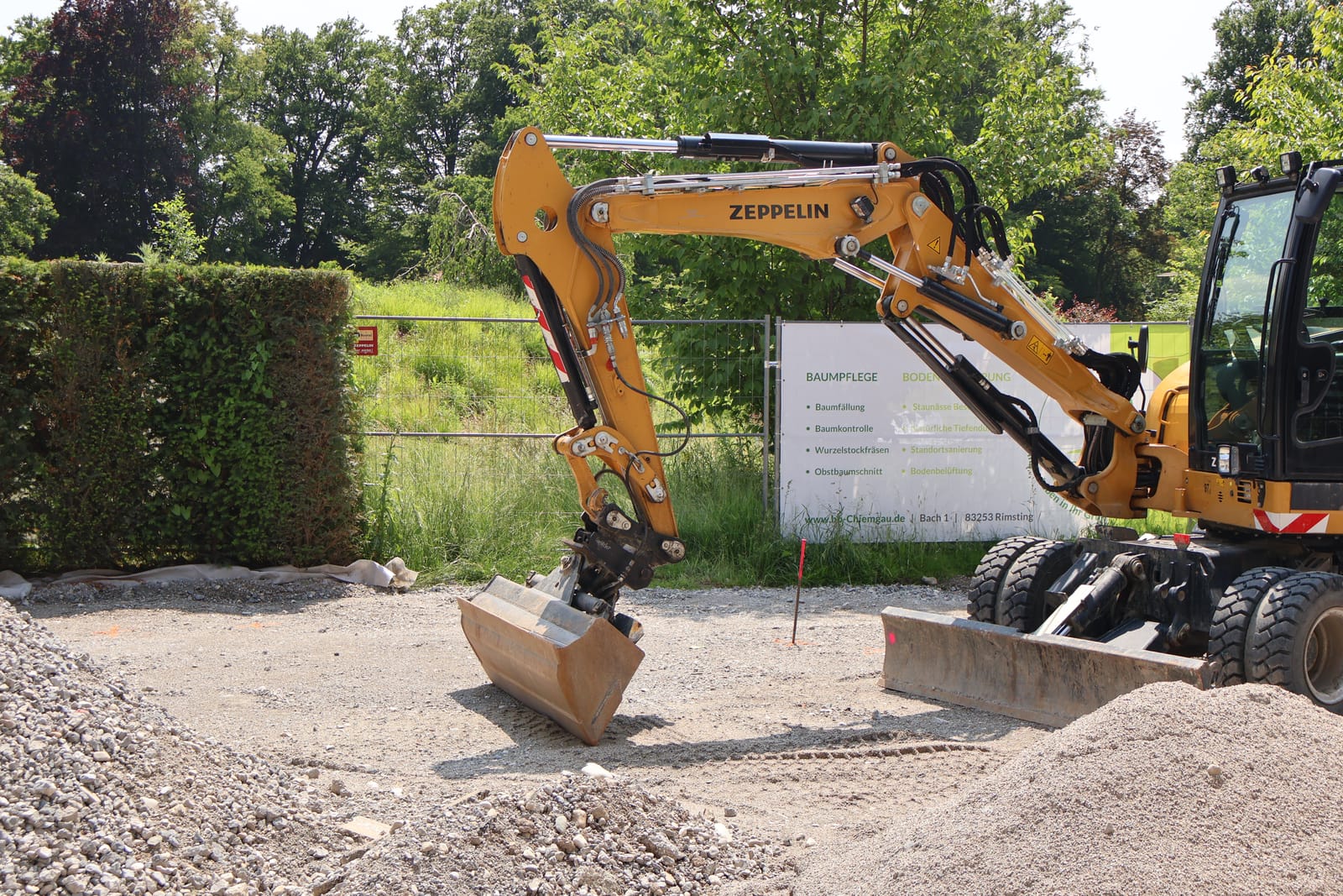 Zeppelin-graafmachine met Redsun-terrasloggen bij een afgerond hoveniersproject in Zutphen, inclusief afwatering.