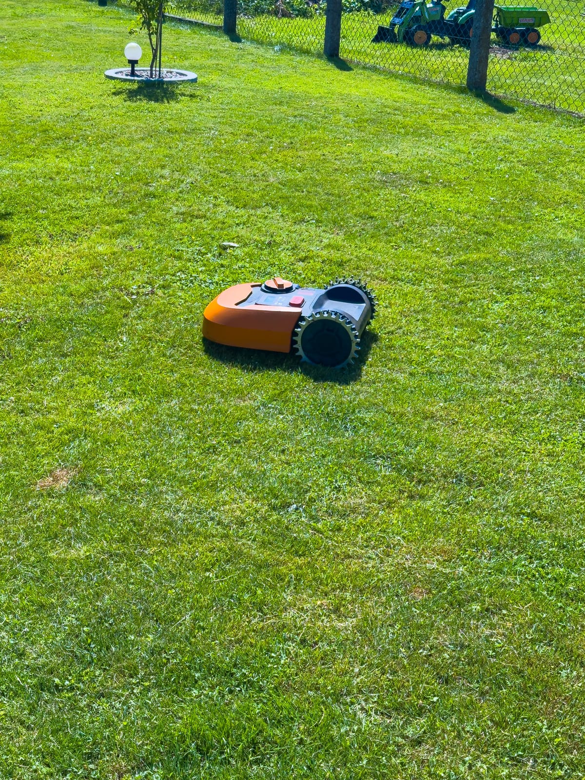 Robuuste MBI-keramische tegels in een Brummse tuin, omgeven door een groene border met vaste planten en siergrassen.
